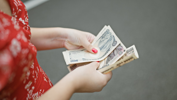 Hands holding Japanese yen currency notes