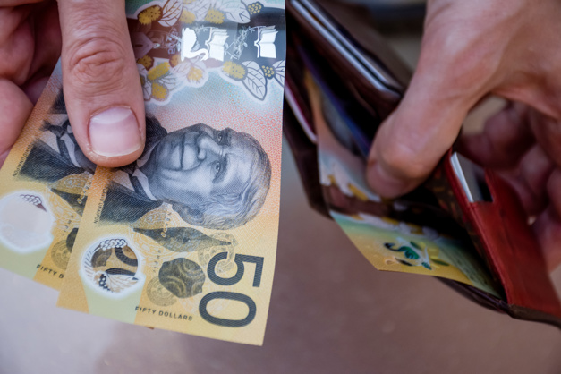 Hands holding Australian dollar notes