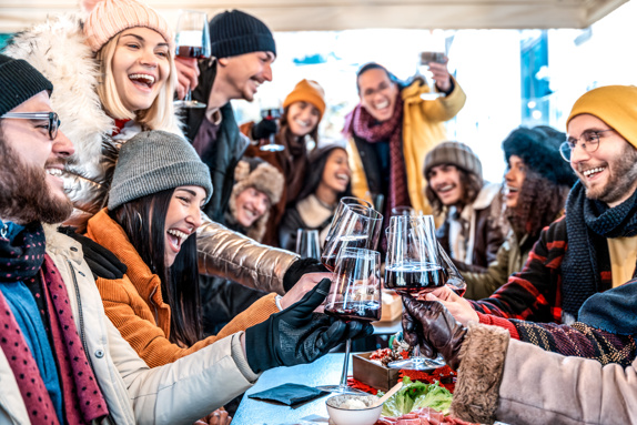 Group of friends in winter clothes at an outdoor restaurant