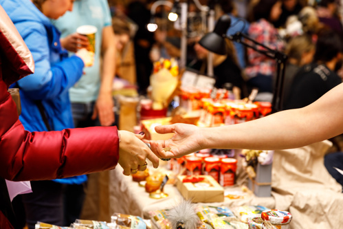 A customer buying items with cash at a Christmas market in Europe